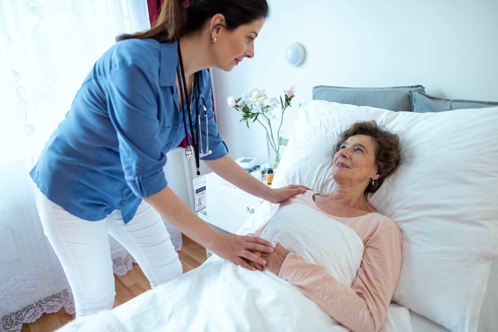 CHPN Recertification and Continuing Education Hospice nurse providing Hospice and Palliative Care to an elderly woman in a hospital bed, related to CHPN certification and continuing education