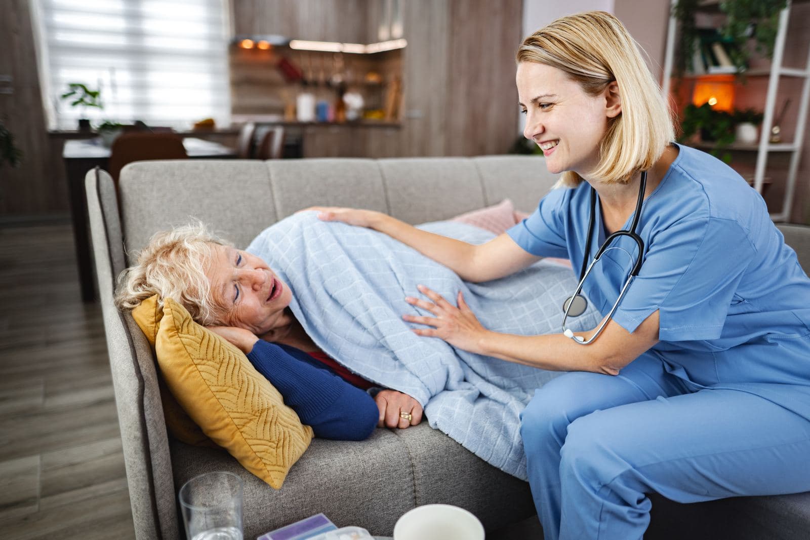 CHPNA Certification – Hospice and Palliative Nursing Assistant Caregiver comforting a senior woman on a sofa at home, reflecting the compassionate hospice and palliative care central to the CHPNA certification