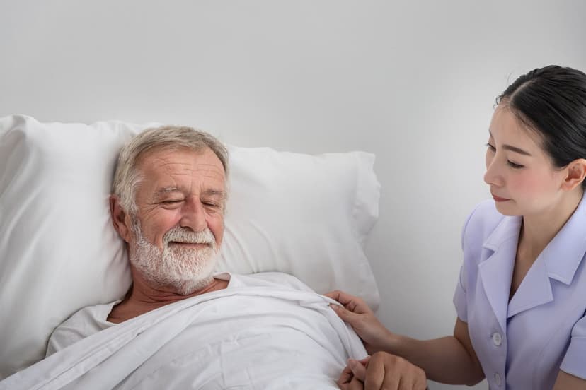 Your Path to CHPNA Certification Nursing assistant caring for an elderly man with a blanket, illustrating hospice and palliative care for CHPNA certification exam preparation