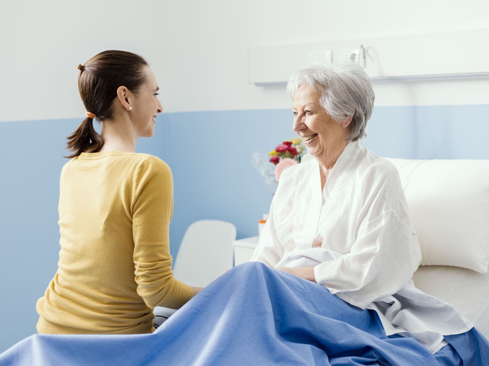 CHPPN Exam Practice Questions Young woman visiting her grandmother in the hospital, reflecting hospice and palliative care for CHPPN certification exam preparation